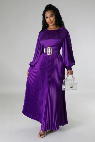 A woman in purple dress holding a white purse.