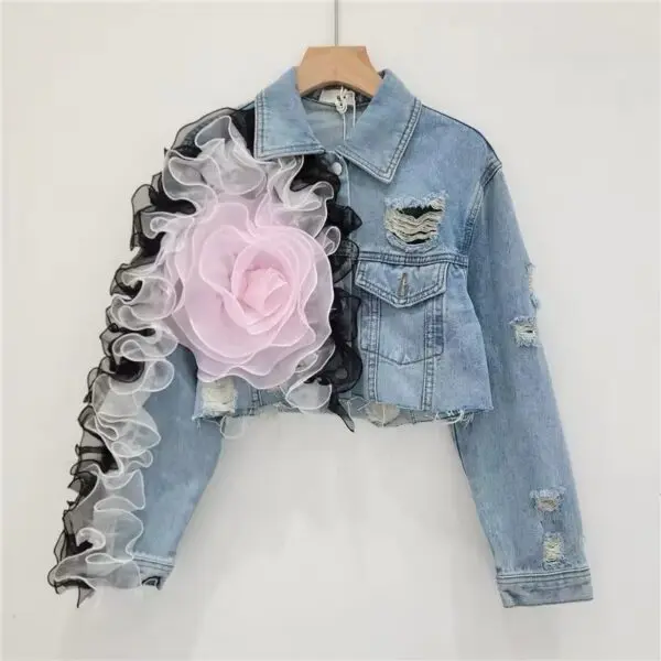 A denim jacket with a flower on the arm.